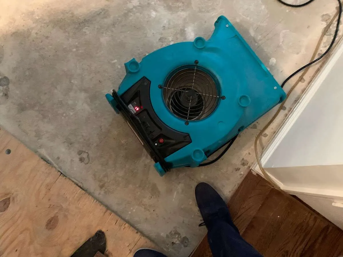 Air mover drying subfloor during Commercial Water Damage Restoration in Castle Pines